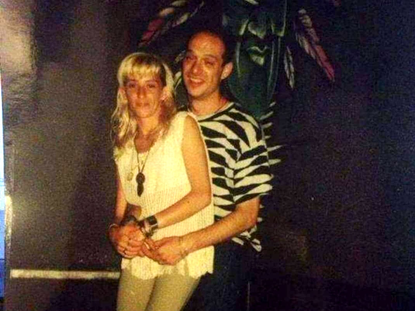 Pareja delante del mural de la máscara en Specka